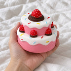 Strawberry cake squishy jumbo, held toward the camera, first-person view