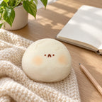 Taba Squishy Hamster Daifuku, Extra Soft (white), on a desk with a notebook and pencil
