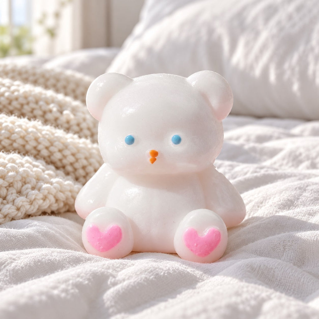 Teddybeer squishy, wit met hartjespootjes, 7 cm, op een knus bed met zachte dekens