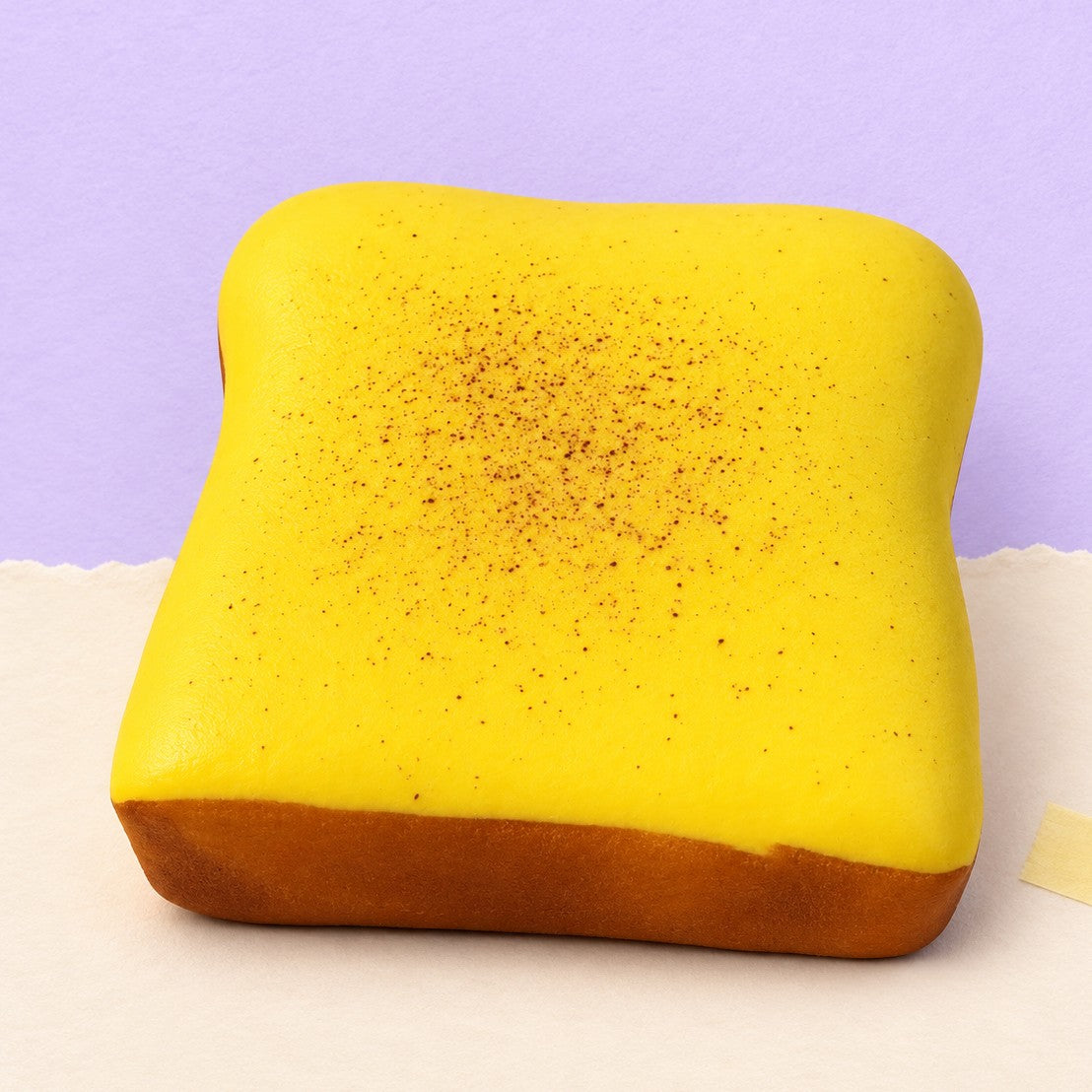 Thick toast squishy – Thick Toast Squishy, Pillow Slice 11 cm (Butter yellow), product photo on pastel paper