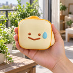 Toast squishy kawaii (Smiley toast), held in a hand to show the real size