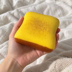 Thick toast squishy (Butter yellow), held toward the camera, first-person view