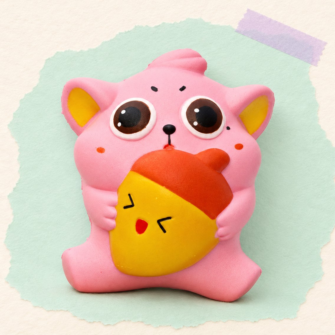 Tyk kat-squishy med agern, produktfoto på pastelfarvet papir