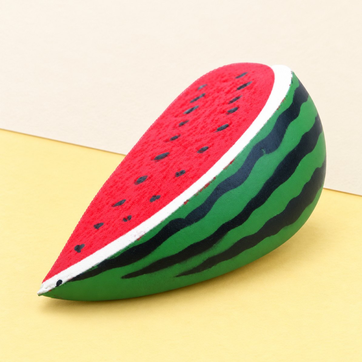 Vandmelon-squishy af PU-skum, produktfoto på pastelfarvet papir