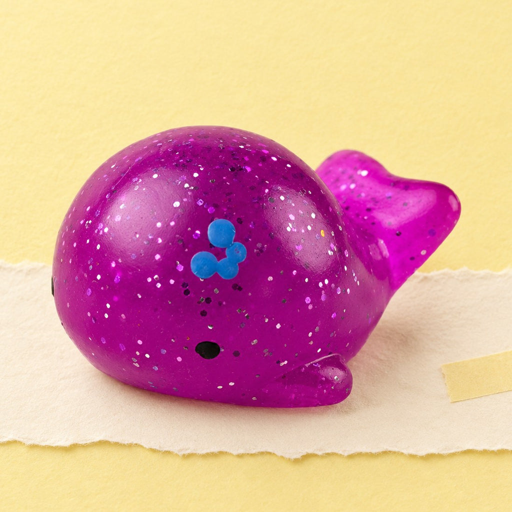 Hval squishy mochi – Mochi squishy hval med glimmer, produktbillede på pastelpapir