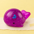 Hval squishy mochi – Mochi squishy hval med glimmer, produktbillede på pastelpapir