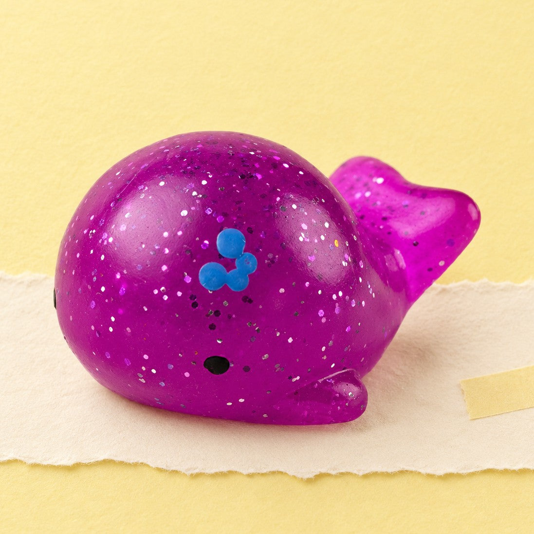 Hval squishy mochi – Mochi squishy hval med glimmer, produktbillede på pastelpapir