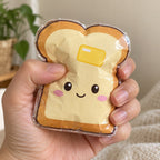 Wide clear tape for paper squishies, on a glossy toast squishy squeezed in the hand