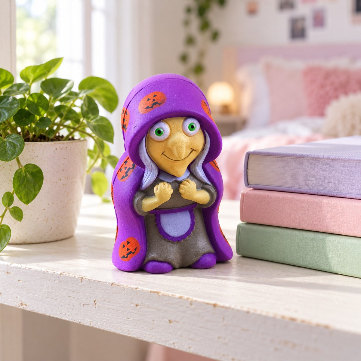 Witch Squishy for Halloween, Slow Rising, on a shelf with books and a plant as room decor