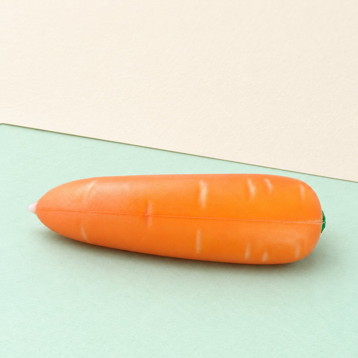 Crunchy wortel squishy, krokante groente van PU op pastelkleurig papier